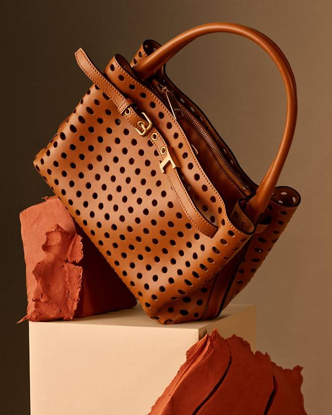 뉴 T 타임리스 핸들 백은 퍼포레이션 기법을 적용해 여름철 경쾌하게 들 수 있다. 사진 토즈