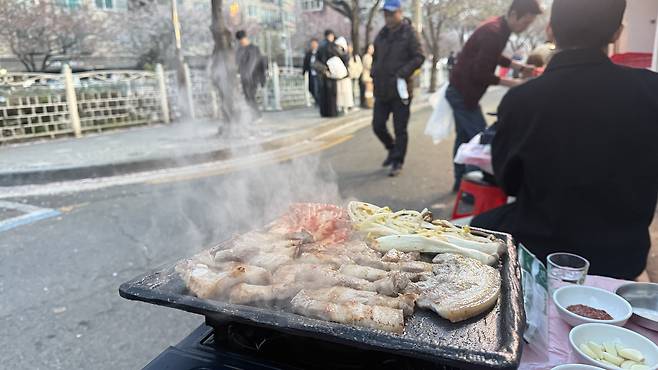 Samgyeopsal (pork belly) sizzles on a grill at one restaurant near Seongbuk Stream on April 11. [WOO JI-WON]