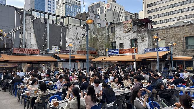 Outdoor tables at Dalmaji Square Barbecue in Euljiro, central Seoul, are filled with diners on April 12. [WOO JI-WON]