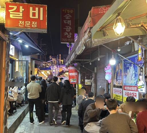 People dine at outdoor tables in alleyways in Jongno District, central Seoul. [SCREEN CAPTURE]