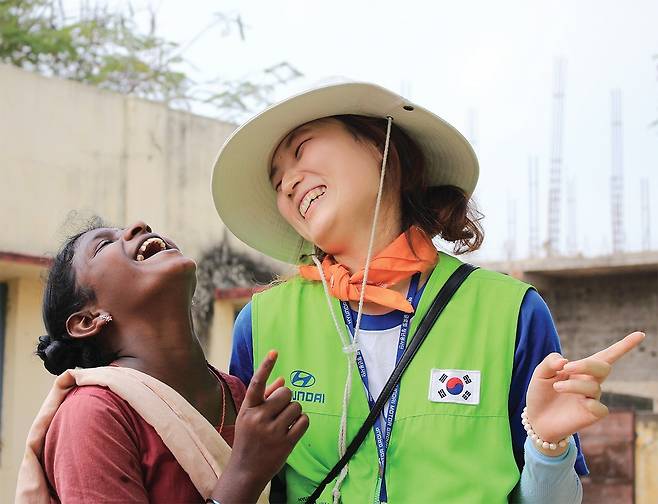 현대차그룹의 대학생 해외봉사단 ‘해피무브’에 참여한 자원봉사자가 현지 여성과 대화를 나누며 환하게 웃고 있다. [현대자동차그룹 제공]