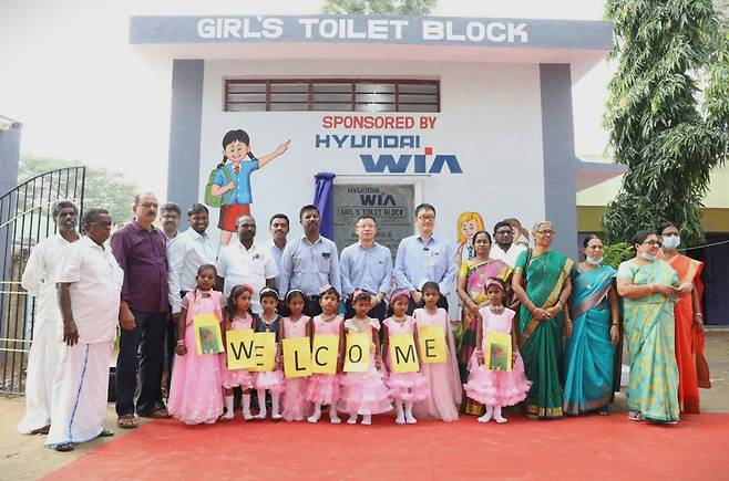 현대위아 임직원들이 인도 센가두 지역에서 열린 ‘여성 화장실’ 준공 행사에서 현지 주민 및 여학생들의 환영을 받고 있다. [현대자동차그룹 제공]