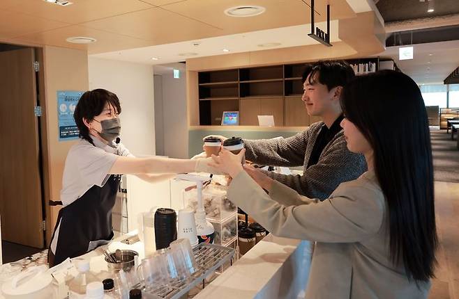 [서울=뉴시스] 한화생명 본사 63빌딩 사내 카페에서 바리스타 직원이 임직원에게 음료를 전달하고 있다. (사진=한화금융 제공) 2026.04.17. photo@newsis.com *재판매 및 DB 금지