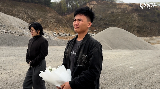 지난 10일, 故 뚜안 씨의 스물세 번째 생일이었던 이날, 남동생 뚜 씨가 국화 꽃다발을 들고 형이 숨진 사고 현장으로 걸어가고 있다. 사진: 유족 측 제공