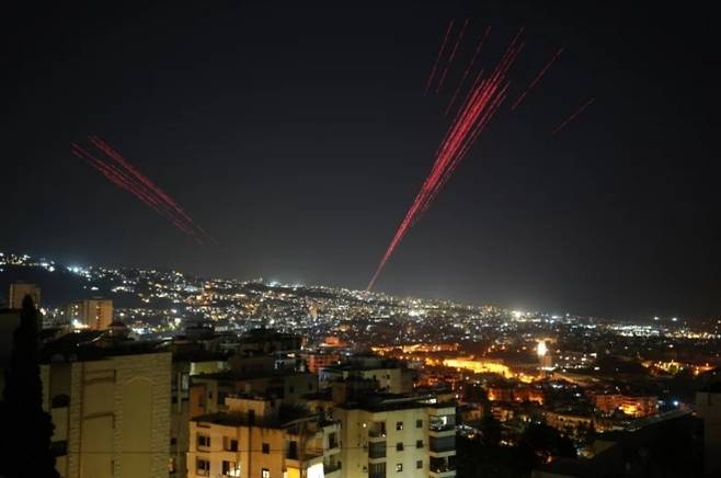 17일(현지시간) 레바논 베이루트에서 이스라엘과 헤즈볼라 간의 휴전이 시작되면서 사람들이 실탄과 폭죽을 공중으로 발사하는 가운데, 예광탄이 밤하늘을 밝히고 있다. AP 연합뉴스