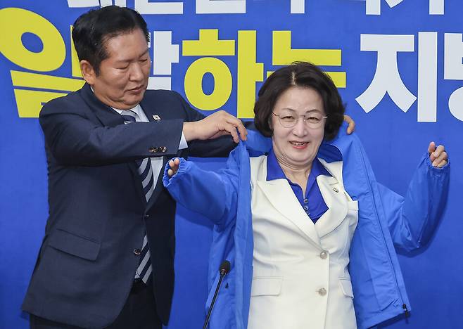 정청래 더불어민주당 대표가 4월13일 국회에서 최고위원회의에 앞서 열린 추미애 경기지사 후보 환영식에서 추 후보에게 선거용 점퍼를 입혀주고 있다. ⓒ연합뉴스