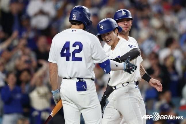 LA 다저스 김혜성이 16일(한국시간) 미국 캘리포니아주 로스앤젤레스 유니클로 필드 앳 다저스타디움에서 열린 뉴욕 메츠와 2026 메이저리그(MLB) 홈경기에서 2회 투런 홈런을 터트리고 홈을 밟은 뒤 동료들의 환영을 받고 있다. /AFPBBNews=뉴스1