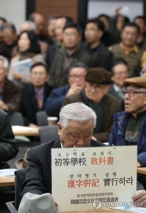 초등생에게 한자 교육을 2016년 11월 30일 서울대학교 호암교수회관에서 열린 '초등학교 교과서 한자 표기 방안 연구진' 주관 토론회에서 한 참석자가 한자 표기 찬성 피켓을 들고 있다. [연합뉴스 자료사진]