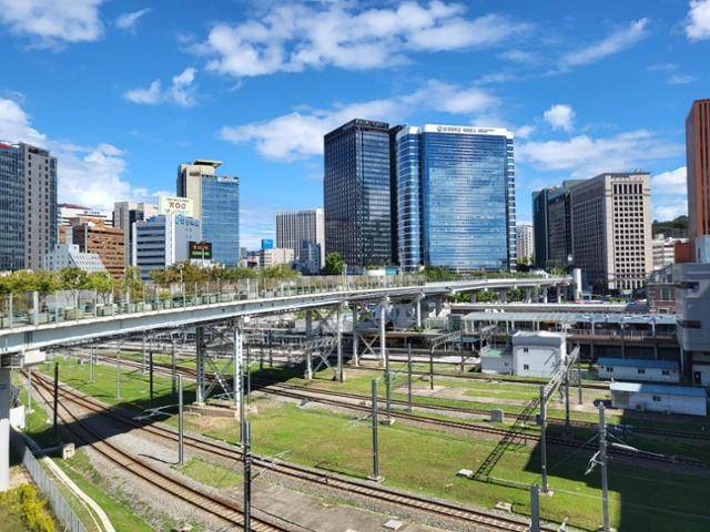 서울역 롯데마트 옥상 쪽에서 바라본 서울로7017(철길 위 다리)의 모습. 이 공중보행로는 빌딩 숲 사이 퇴계로에서 뻗어나와 탁 트인 서울역 광장을 건너, 서부역 쪽으로 곧장 이어진다. 한국일보 자료사진