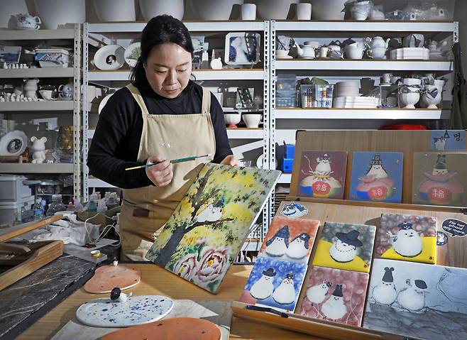 Kim Eun-kyung applies glaze to a painted porcelain slab. [PARK SANG-MOON]