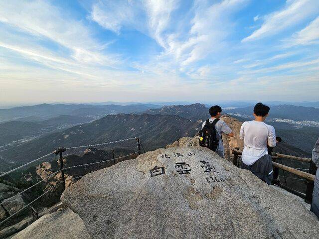 북한산 정상인 백운대에 오른 등산객들이 서울 도심을 바라보고 있는 모습.