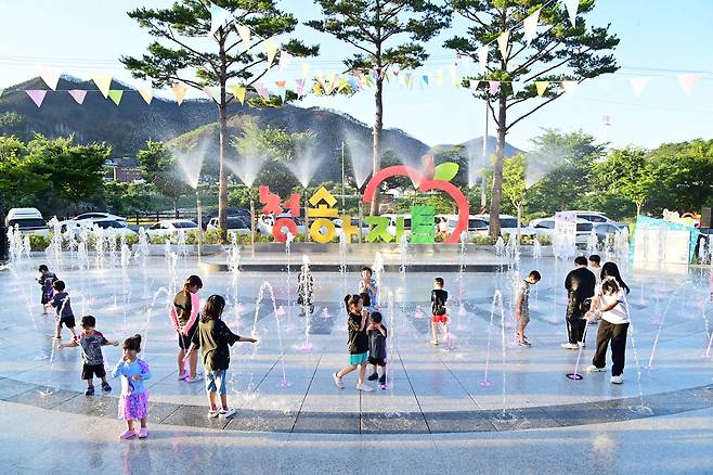 청송아지트에 설치된 바닥분수에 아이들이 물줄기 사이를 가로지르며 뛰어 놀고 있다./청송군제공