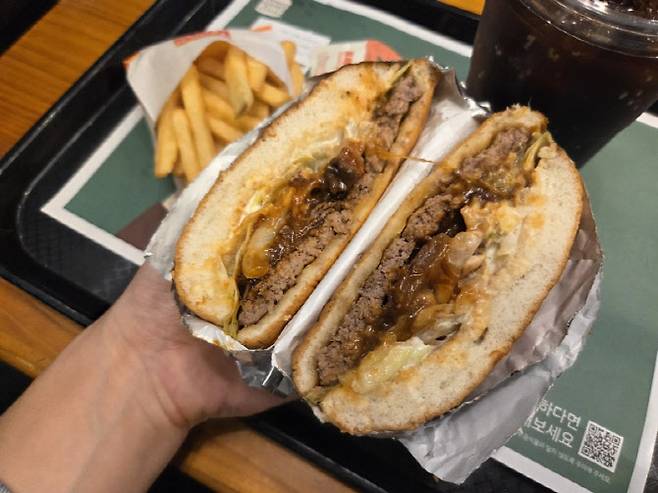 반으로 자른 ‘스모크 비프립 와퍼’ 단면. 패티 위에 올라간 큐브 스테이크와 진한 소스가 층을 이룬다. (사진=한전진 기자)