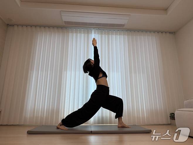 김유빈 요가강사가 전사자세1을 보여주고 있다. 한쪽 다리를 앞으로 내딛어 런지 형태로 서고, 팔을 위로 뻗어 상체를 뒤로 젖히는 요가 기본자세다. 하체 근력과 안정성, 코어 지지력, 골반·척추 정렬 인식, 흉곽 확장 및 호흡 질 개선에 도움이 된다.ⓒ 뉴스1 서장원 기자