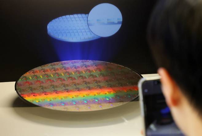 지난 2월 11일 서울 강남구 코엑스에서 열린 세미콘 코리아 2026에서 한 관람객이 반도체 웨이퍼를 살펴보고 있다. /뉴시스