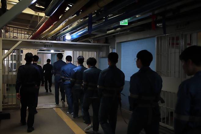 지난 15일 법조 기자단이 안양교도소에서 수용자들이 법정으로 가기 위해 이동하는 출정 절차를 체험하고 있다. /법무부 제공