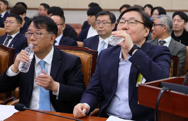 지난 4월 14일 국회 ‘윤석열 정권 정치검찰 조작기소 의혹 사건 진상규명’ 국정조사특별위원회에서 열린 경기도-쌍방울그룹 대북송금 공모 사건 관련 청문회에서 유죄 확정판결을 받은 이화영(외른쪽) 전 경기도 평화부지사와 그 변호인이었던 서민석(왼쪽) 당시 더불어민주당 청주시장 예비후보가 물을 마시고 있다.[연합뉴스 사진]