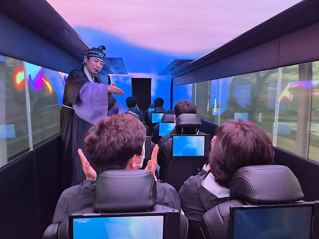 지난 17일 경북 경주시가 운영하는 '골든 신라 경주 XR 버스'에서 탑승객들이 가이드의 진행에 따라 퀴즈를 풀고 있다. 김정석 기자