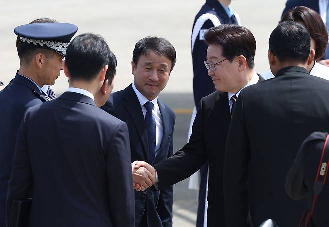 이재명 대통령이 공군 1호기 탑승 전 환송객들과 인사하고 있다.