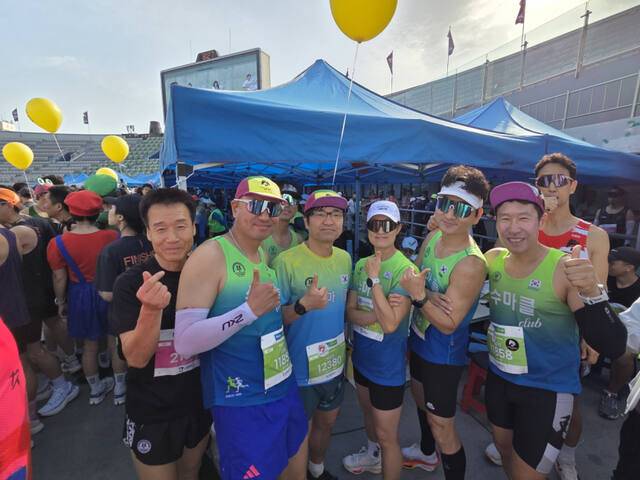 19일 오전 수원종합운동장에서 열린 ‘제24회 경기마라톤대회’ 수원마라톤클럽 부스에서 회원들이 포즈를 취하고 있다. 부석우 기자