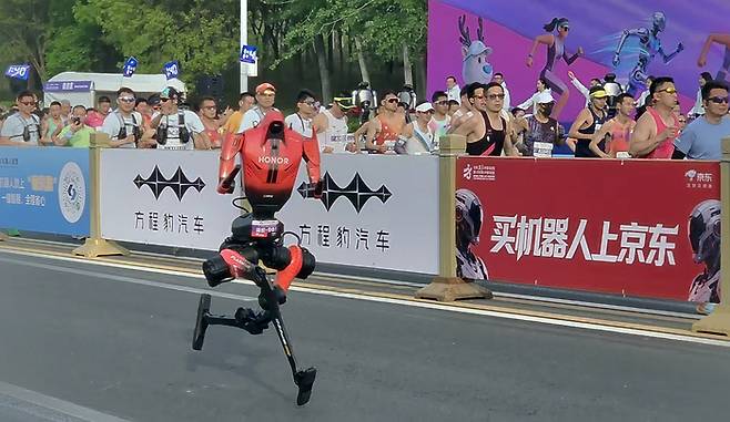 19일 중국 베이징시 이좡에서 개최된 ‘제2회 휴머노이드 로봇 하프마라톤 대회’에 참가한 아너의 ‘샨뎬’이 출발해 빠르게 뛰고 있다. [연합뉴스]