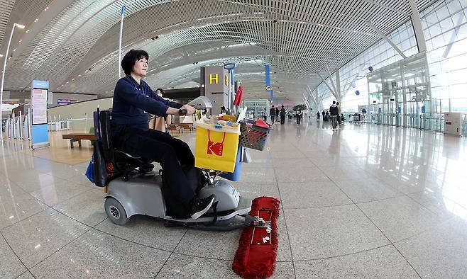 인천공항 운영서비스 직원 이정숙씨가 제2 터미널 출국장에서 청소차로 바닥의 먼지를 제거하고 있다.