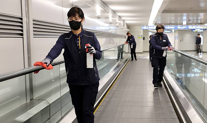 인천공항운영서비스 직원들이 인천국제공항 여객터미널에서 먼지를 제거하는 걸레질을 하고 있다.