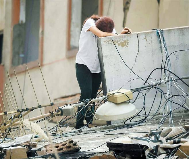 집에 돌아왔지만 집이 없어졌어요  18일 레바논 베이루트 남부 마을에서 한 주민이 괴로운 듯 벽에 몸을 기대고 있다. 이스라엘과 레바논은 지난 16일 열흘간 휴전에 돌입했지만, 곳곳에서 포성이 멈추지 않고 있다. /AFP 연합뉴스