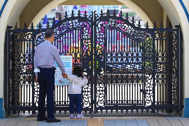12일 휴장 중인 대전 중구 오월드 입구 앞에서 한 어린이가 아쉬운 듯 내부를 들여다보고 있다. /신현종 기자
