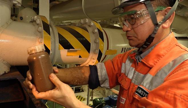 일본 해양지구과학기술청(SIP) 소속 연구원이 2026년 2월 1일 도쿄 남쪽 미나미토리시마 앞바다에서 채취한 희토류가 풍부한 진흙을 병에 담고 있다. /연합뉴스