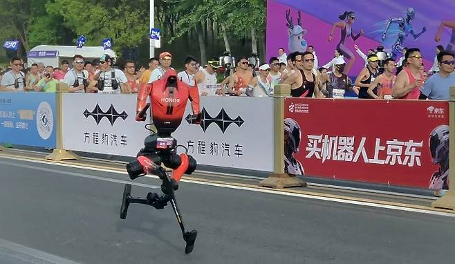 19일 중국 베이징에서 열린 제2회 휴머노이드 로봇 하프마라톤에서 아너의 '샨뎬'이 출발 직후 빠르게 달리고 있다. 자율주행 부문 우승팀은 샨뎬을 훈련시켜 50분 26초에 완주했다. 연합뉴스 제공