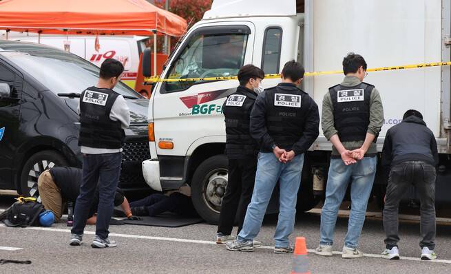 경찰이 20일 경남 진주시 정촌면 비지에프(BGF)로지스 진주센터에서 화물연대 관계자 1명이 숨지고, 2명이 다친 사고와 관련해 현장에서 사고 차량을 조사하고 있다. 연합뉴스