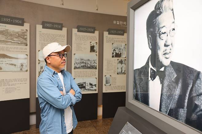 유한양행 창업주 유일한의 일대기를 다룬 웹툰 ‘NEW 일한’을 그린 윤태호가 서울 대방동 유한양행 본사 1층에 있는 ‘유일한 기념관’에서 유일한의 사진을 바라보고 있다. [사진 유한양행]