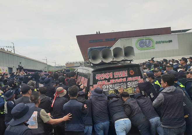 극한 대치 화물연대 노조원들이 20일 경남 진주시 정촌면 BGF로지스 진주센터에서 센터 입구로 진입을 시도하면서 이를 막는 경찰과 대치하고 있다.  연합뉴스