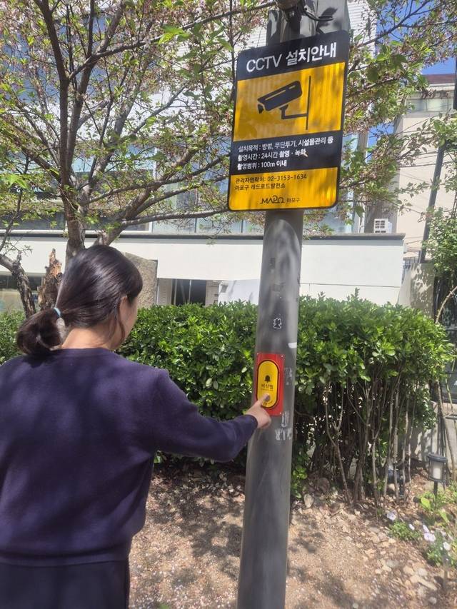 서울 마포구 홍대 레드로드 발전소 인근에 설치된 비상벨을 마포구 관계자가 점검하고 있다. 마포구청 제공