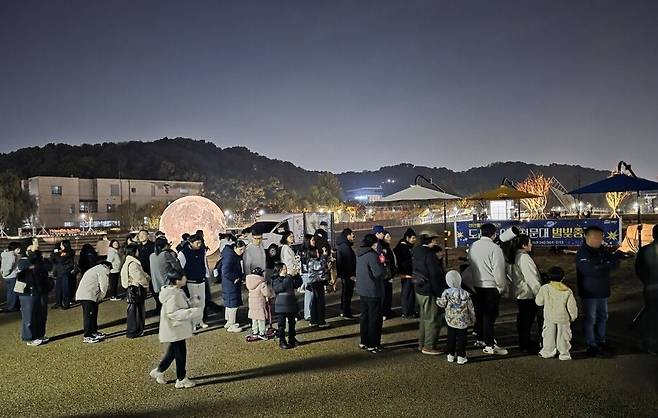지난 2025년 11월 천안삼거리공원에서 운영된 이동천문대에서 어린이들이 스마트폰으로 달 사진 촬영 체험에 참여하고 있다.&nbsp;ⓒ천안시 제공
