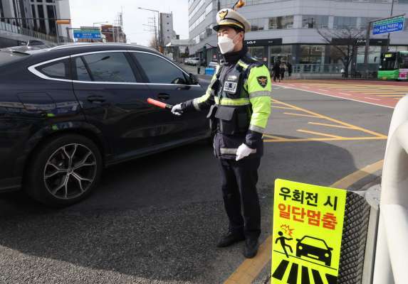 우회전 일시 정지 계도 및 단속 활동을 벌이는 경찰