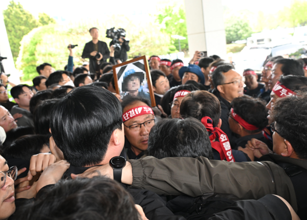 21일 화물연대 소속 노동자 등이 희생자 영정사진을 들고 경남경찰청 앞에서 진주 예하리 노동자 사망 관련 CU BGF로지스와 경찰을 규탄하는 화물연대 기자회견을 마친 후 항의방문하고 있다. 희생 노동자는 20일 오전 10시 32분께 진주시 정촌면 예하리 BGF로지스 진주센터 인근 민주노총 화물연대 경남지역본부 소속 CU편의점 화물운송 노동자 집회 현장에서 사망했다./김구연 기자