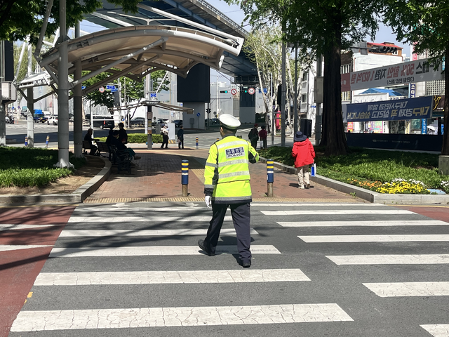 한 경찰관이 우회전 차량을 멈추고 시민들의 횡단보도 통행을 안내하고 있다. 김정원 기자