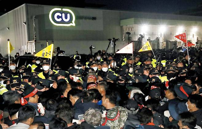 경찰·화물연대, 밤까지 대치  20일 밤 경남 진주 정촌면 CU 진주물류센터 앞에서 민주노총 화물연대 조합원들과 경찰이 몸싸움을 하고 있다. 물류센터에 진입하려는 조합원들을 경찰이 저지하고 있다. 이날 오전 이 곳에선 물류센터를 출발한 화물차와 집회 참가자가 충돌해 1명이 숨지고 2명이 다쳤다. /뉴스1