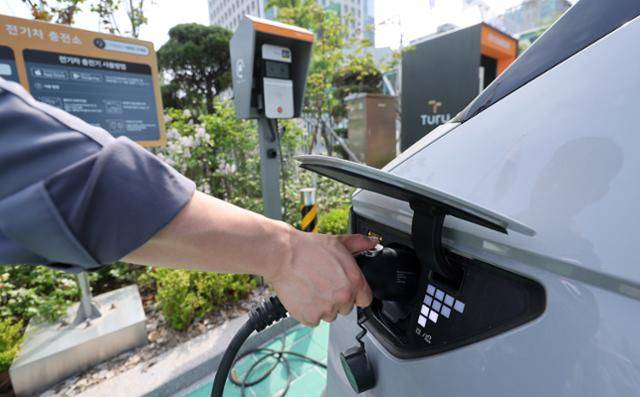19일 서울 한 건물의 전기차 충전소에서 이용자가 차량에 충전기를 연결하고 있다. 뉴스1