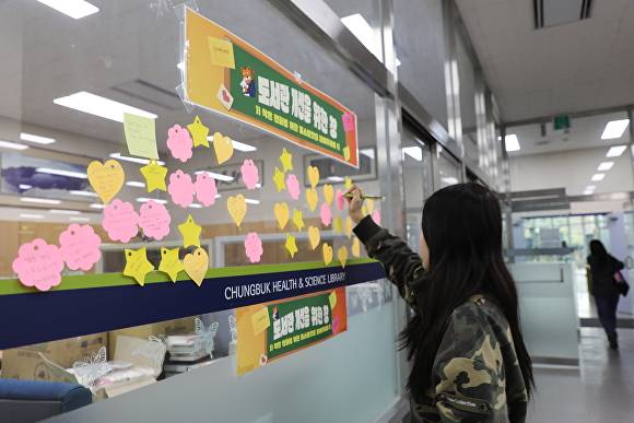 한 학생이 도서관 개선의 창 게시판에 의견을 메모하고 있다. [사진=충북보건과학대학교]