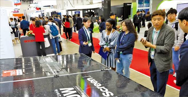 지난해 엑스코에서 열린 대구국제그린에너지엑스포에서 바이어들이 태양광 셀과 모듈 제품에 관한 설명을 듣고 있다.  엑스코 제공
