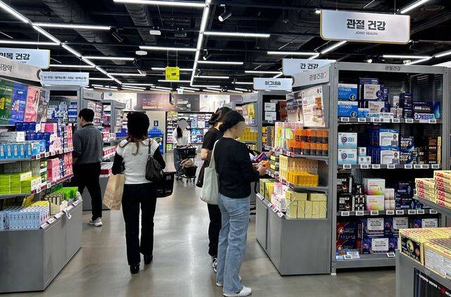 소비자들이 지난 17일 서울 용산구의 창고형 약국 ‘메디킹덤’에서 진열된 약을 둘러보고 있다. 증상을 말하면 약사가 약을 꺼내주는 일반 약국과 달리 소비자가 직접 약을 골라 구매하는 방식이다.