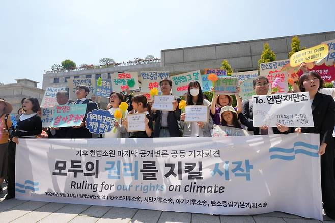2024년 5월 21일 헌법재판소 앞에서 열린 기후 헌법소원 공동 기자회견. 윤세종 변호사가 '안정된 기후에서 살아갈 권리' 문구가 적힌 손팻말을 들고 서있다. 청소년기후행동 제공