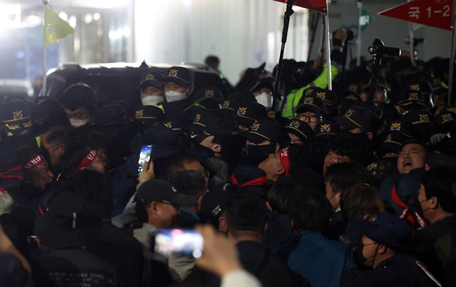 20일 오후 경남 진주시 정촌면 BGF로지스 진주센터에서 화물연대 관계자가 센터 입구로 진입하려는 과정에서 경찰과 대치하고 있다. [연합뉴스]