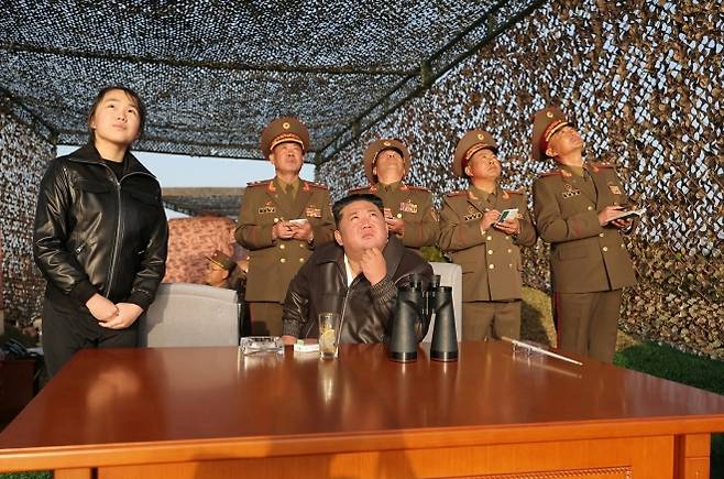 김정은, 주애와 참관… 시험 결과에 ‘대만족’ - 김정은 북한 국무위원장과 딸 주애(왼쪽)가 군 관계자들과 함께 지난 19일 집속탄두와 파편지뢰탄두를 탑재한 지상대지상전술탄도미사일 ‘화성포-11라’의 시험발사를 참관하고 있다. 평양 노동신문·뉴스1