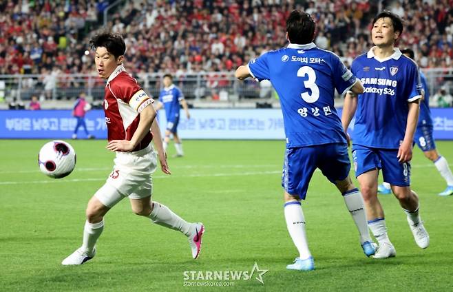 박지성(왼쪽)이 수원 삼성 레전드와 경기에서 드리블을 시도하고 있다. /사진=강영조 선임기자
