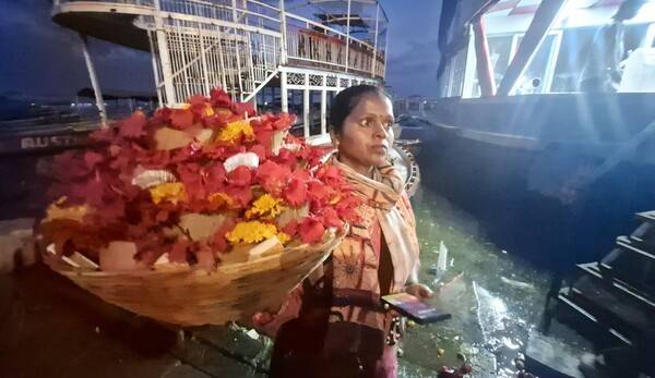 한 소녀가 소원을 담아 강에 띄우는 꽃 등을 팔고 있다.