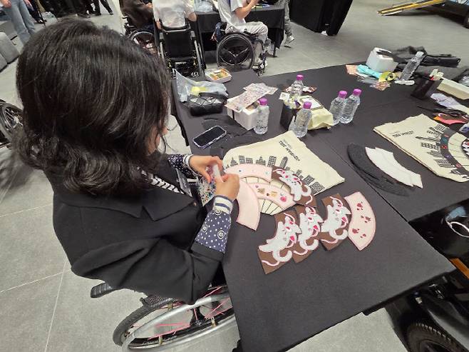 20일 오후 기아가 주최한 휠체어 꾸미기 행사에 참여한 모주영(43) 씨가 '휠꾸' 소품을 골라 붙이고 있다. (사진= 김현재 기자)